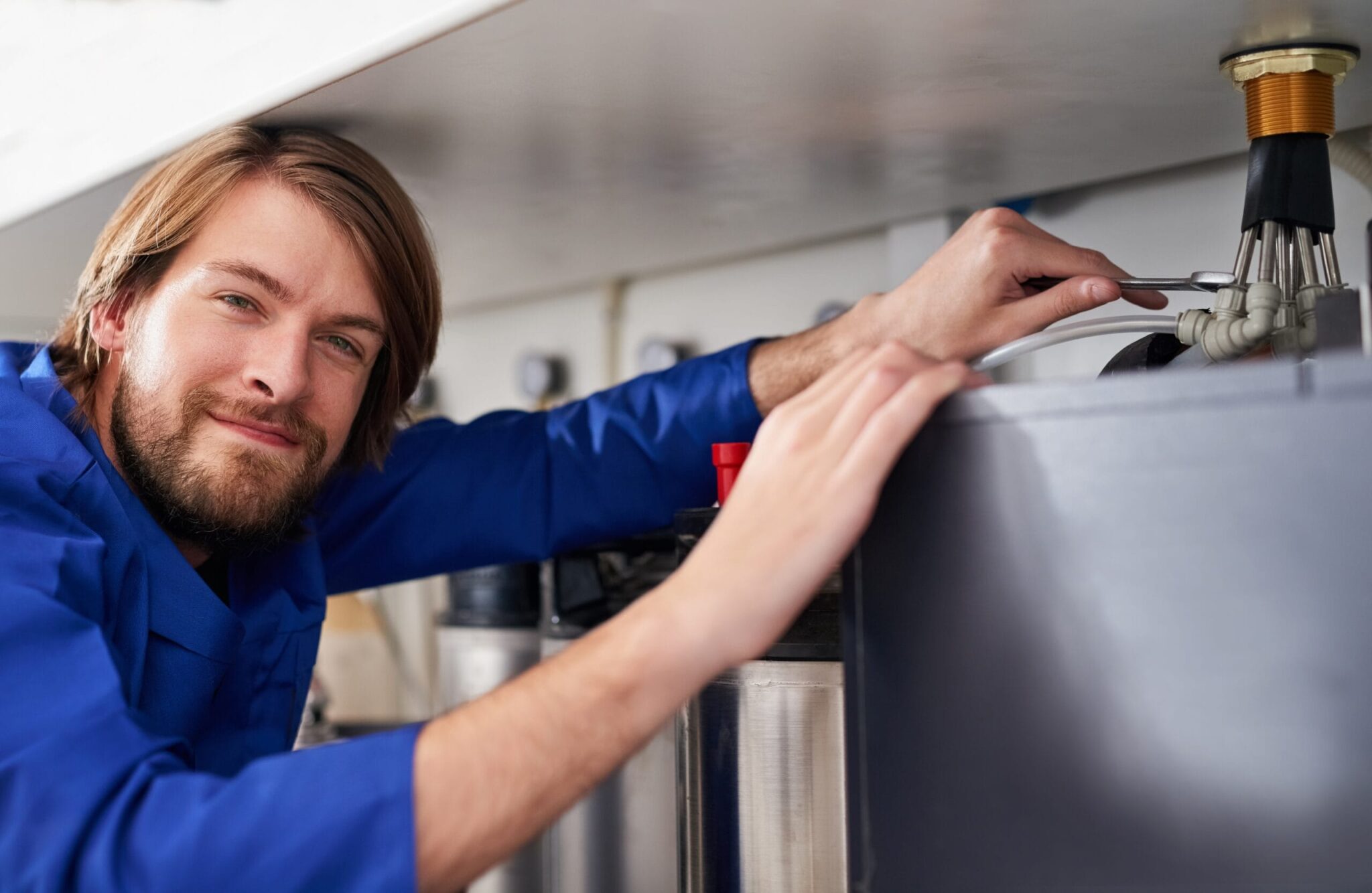Technician servicing a residential water heater tank in San Ramon